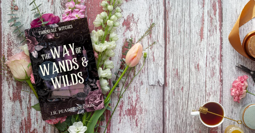 The Way of Wands & Wilds paperback by paranormal romance author J.R. Pearse Nelson on a cozy background.
